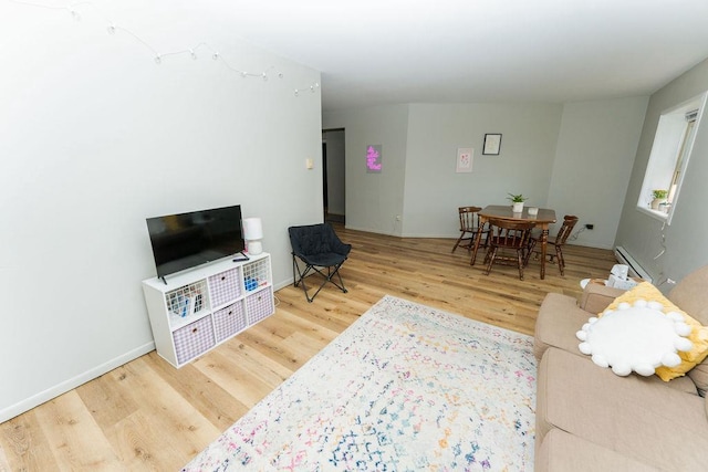 306 Wisconsin St, Oshkosh, WI 54901 - living room featuring wood finished floors, a baseboard radiator, and baseboards