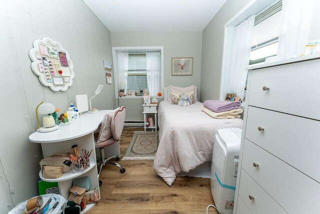 306 Wisconsin St, Oshkosh, WI 54901 - bedroom with wood finished floors, multiple windows, and a baseboard heating unit