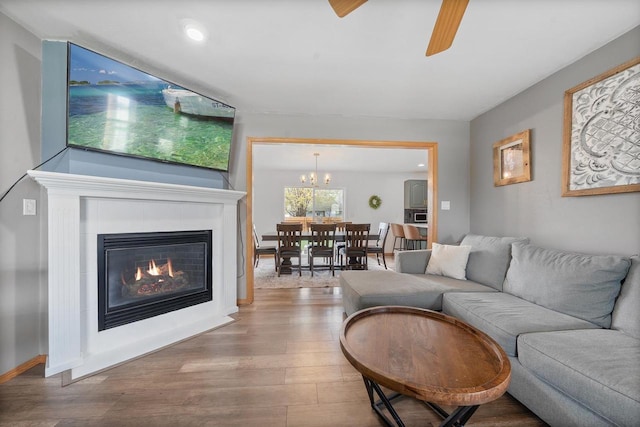 2731 Hamilton St, Oshkosh, WI 54901 - living room featuring wood finished floors, a glass covered fireplace, ceiling fan, a chandelier, and recessed lighting