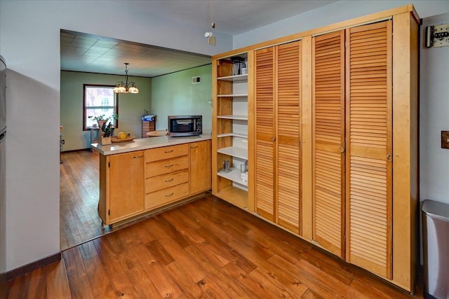 1614 Lake View Ave, Madison, WI 53704 - kitchen with stainless steel microwave, open shelves, a peninsula, dark wood-style floors, and a chandelier
