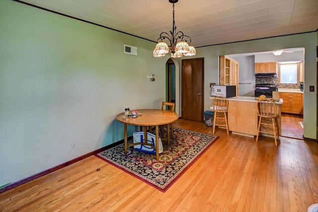 1614 Lake View Ave, Madison, WI 53704 - dining space featuring light wood-style flooring, arched walkways, baseboards, and a chandelier