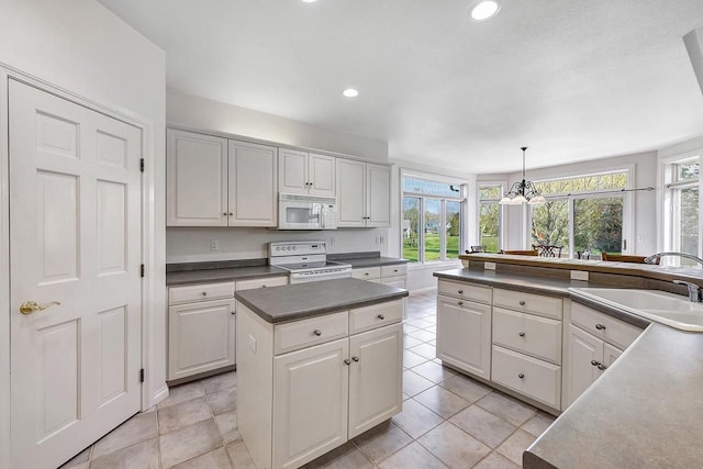 2531 Huntington Way, Suamico, WI 54173 - kitchen featuring white appliances, a sink, dark countertops, a chandelier, and hanging light fixtures
