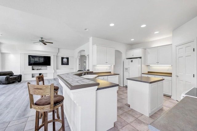 2531 Huntington Way, Suamico, WI 54173 - kitchen featuring arched walkways, white appliances, dark countertops, ceiling fan, and a sink