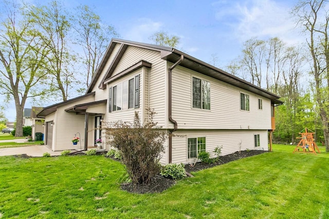 632 Grove St, Portage, WI 53901 - view of home's exterior featuring a playground, an attached garage, a yard, and concrete driveway