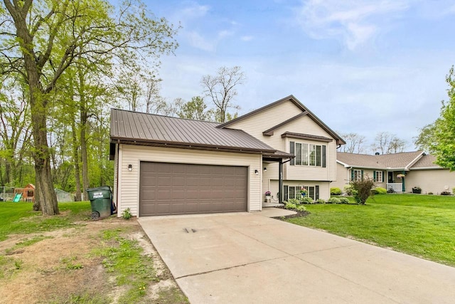 632 Grove St, Portage, WI 53901 - split level home featuring a garage, concrete driveway, a front lawn, and metal roof