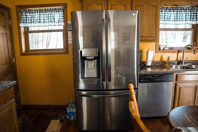 33902 County Rd N Unit L4, Hillpoint, WI 53937 - kitchen with stainless steel appliances, a sink, dark countertops, brown cabinetry, and dark wood-style floors