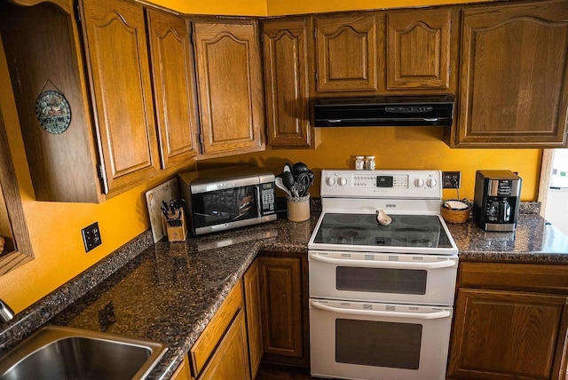 33902 County Rd N Unit L4, Hillpoint, WI 53937 - kitchen with double oven range, exhaust hood, stainless steel microwave, and brown cabinetry