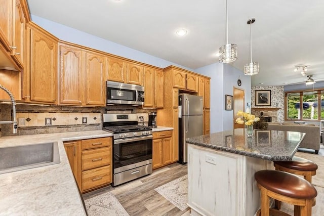226 N Main St Unit 6, Walworth, WI 53184 - kitchen featuring stainless steel appliances, a sink, open floor plan, a kitchen breakfast bar, and a center island