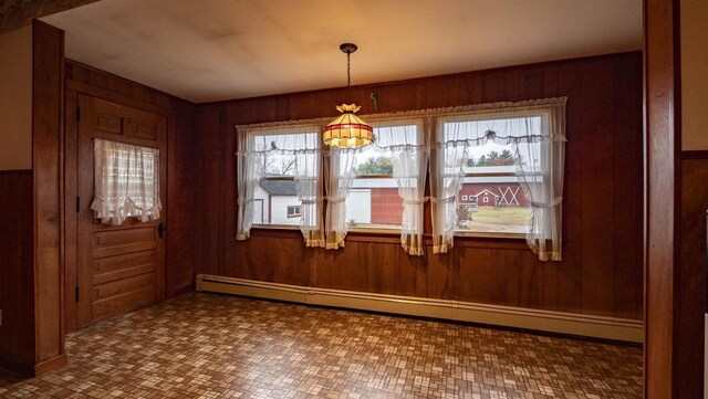 N2145 Lind Center Rd, Waupaca, WI 54981 - unfurnished dining area with a baseboard heating unit and wooden walls