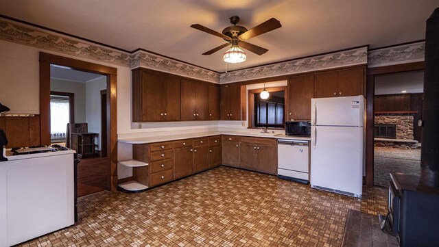 N2145 Lind Center Rd, Waupaca, WI 54981 - kitchen featuring white appliances, light countertops, a ceiling fan, a sink, and a fireplace