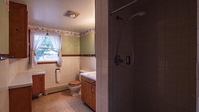 N2145 Lind Center Rd, Waupaca, WI 54981 - bathroom featuring a baseboard radiator, vanity, tiled shower, toilet, and tile walls