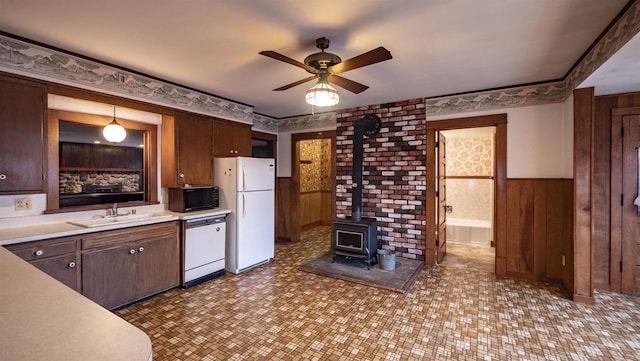 N2145 Lind Center Rd, Waupaca, WI 54981 - kitchen with white appliances, a sink, a wood stove, ceiling fan, and a wainscoted wall