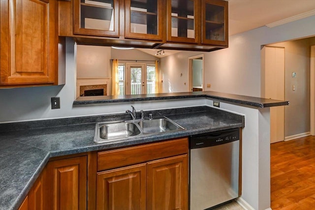 7102 Flagship Dr Unit 8, Madison, WI 53719 - kitchen featuring stainless steel dishwasher, a sink, brown cabinetry, dark countertops, and glass insert cabinets