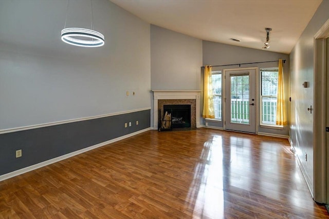 7102 Flagship Dr Unit 8, Madison, WI 53719 - unfurnished living room with vaulted ceiling, wood finished floors, a chandelier, a fireplace with flush hearth, and baseboards