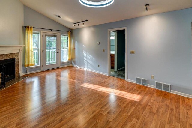 7102 Flagship Dr Unit 8, Madison, WI 53719 - unfurnished living room featuring lofted ceiling, wood finished floors, a premium fireplace, and baseboards