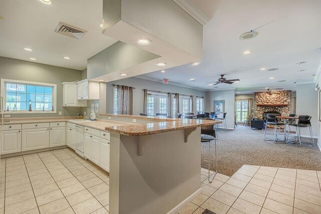 7102 Flagship Dr Unit 8, Madison, WI 53719 - kitchen featuring a peninsula, light tile patterned floors, dishwasher, a breakfast bar area, and ornamental molding