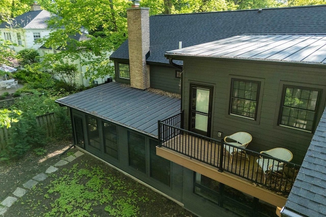 810 Farwell Dr, Madison, WI 53704 - rear view of house with a chimney, metal roof, a standing seam roof, and a balcony