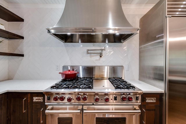 810 Farwell Dr, Madison, WI 53704 - kitchen with double oven range, wall chimney range hood, backsplash, light countertops, and dark brown cabinets