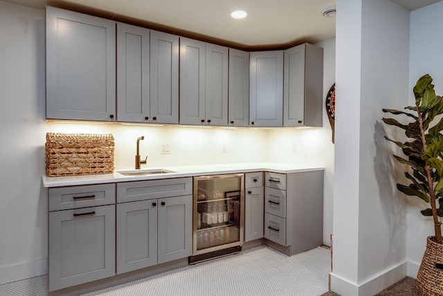 810 Farwell Dr, Madison, WI 53704 - kitchen with wine cooler, gray cabinets, a sink, baseboards, and light countertops