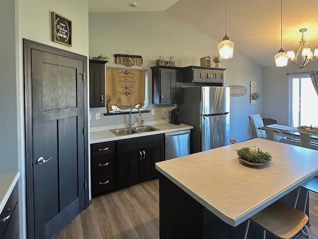 8505 Hinner Springs Dr, Weston, WI 54476 - kitchen with appliances with stainless steel finishes, a sink, vaulted ceiling, light wood-style floors, and light countertops