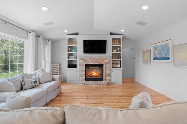 2074 Sandy Springs Rd, De Pere, WI 54115 - living area with vaulted ceiling, light wood finished floors, a fireplace, arched walkways, and recessed lighting