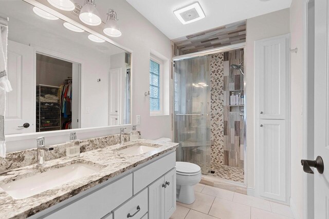 2074 Sandy Springs Rd, De Pere, WI 54115 - full bathroom with a shower stall, toilet, tile patterned flooring, double vanity, and a walk in closet