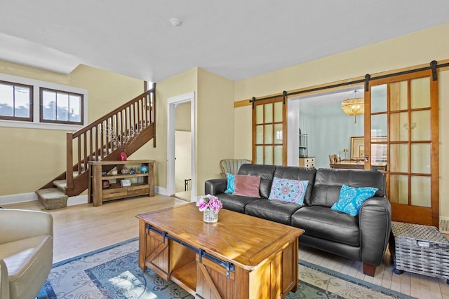 1333 W Lawrence St, Appleton, WI 54914 - living room featuring a barn door, baseboards, stairway, and wood finished floors