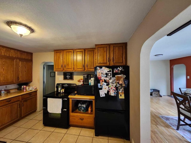 805 S Wacouta Ave, Prairie Du Chien, WI 53821 - kitchen featuring arched walkways, black appliances, and brown cabinets