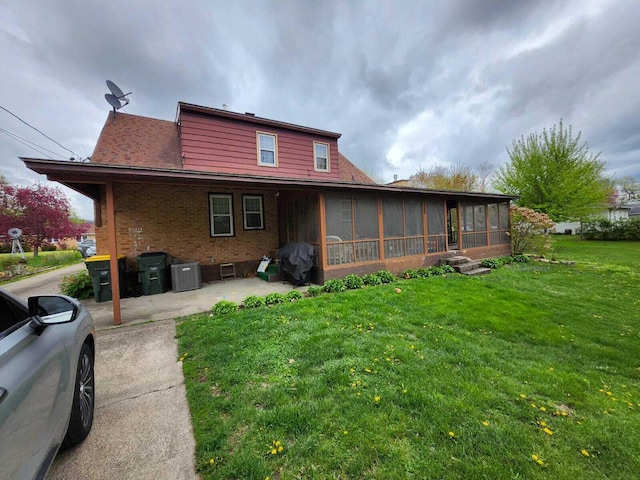 805 S Wacouta Ave, Prairie Du Chien, WI 53821 - back of property featuring a sunroom, brick siding, a yard, a patio area, and cooling unit