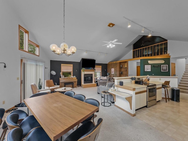 911 Fawn Ln, Port Edwards, WI 54469 - dining room featuring track lighting, stairs, high vaulted ceiling, a glass covered fireplace, and plenty of natural light