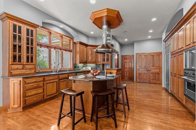 441 E Apple Creek Rd, Appleton, WI 54913 - kitchen with appliances with stainless steel finishes, a kitchen island, a kitchen bar, glass insert cabinets, and light wood-style floors