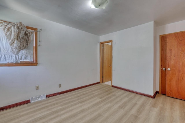 spare room with wood finished floors and baseboards
