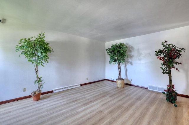 spare room featuring wood finished floors and baseboards