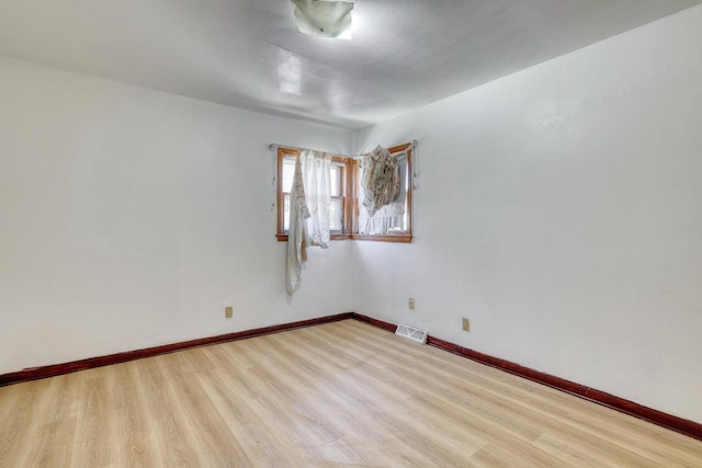 spare room featuring wood finished floors and baseboards