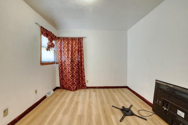 spare room with wood finished floors and baseboards