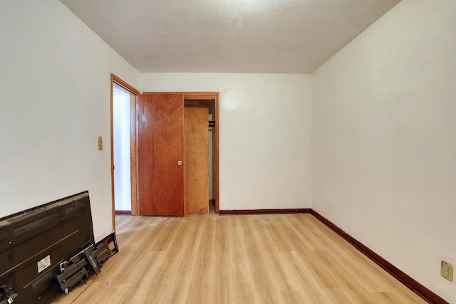unfurnished room featuring wood finished floors and baseboards