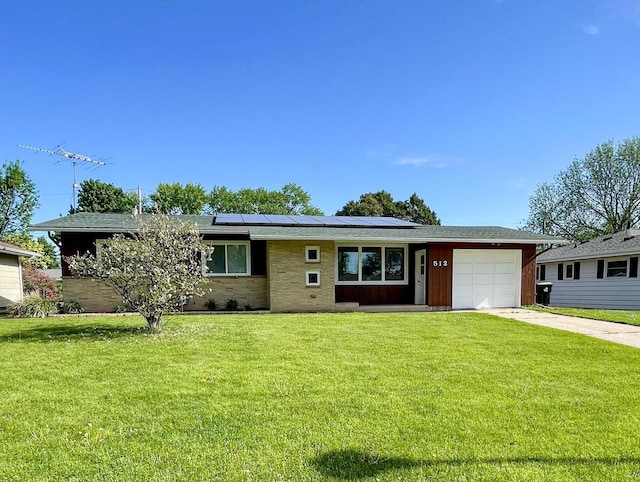 512 Conrad Ln, Beaver Dam, WI 53916 - single story home featuring concrete driveway, a garage, roof mounted solar panels, and a front yard