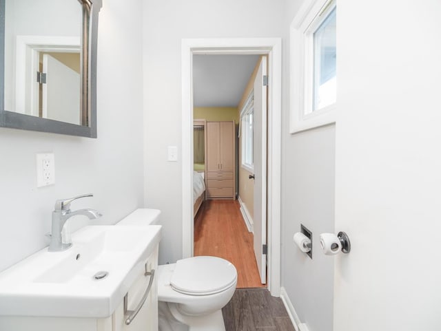512 Conrad Ln, Beaver Dam, WI 53916 - half bath featuring wood finished floors, toilet, baseboards, and vanity