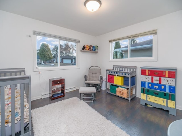 512 Conrad Ln, Beaver Dam, WI 53916 - bedroom featuring a baseboard heating unit, wood finished floors, baseboards, and a crib