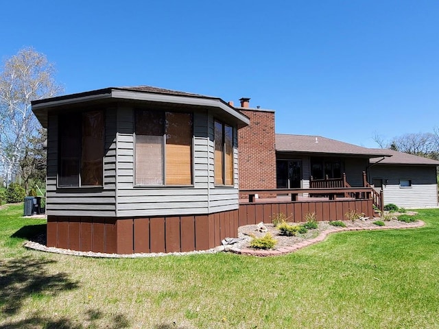 171 8th St, Clintonville, WI 54929 - view of side of property with a chimney, a lawn, and central AC