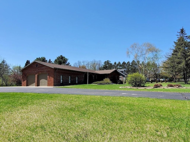 171 8th St, Clintonville, WI 54929 - view of front of home with a front lawn, a garage, asphalt driveway, and brick siding