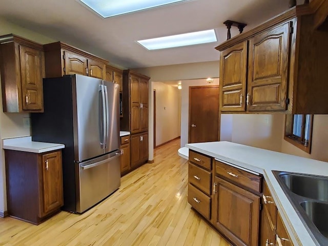 171 8th St, Clintonville, WI 54929 - kitchen with freestanding refrigerator, a sink, light wood finished floors, and light countertops