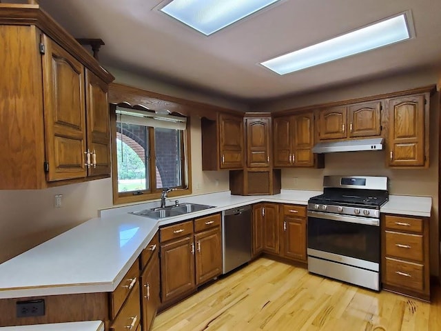 171 8th St, Clintonville, WI 54929 - kitchen featuring appliances with stainless steel finishes, a sink, light wood finished floors, and light countertops