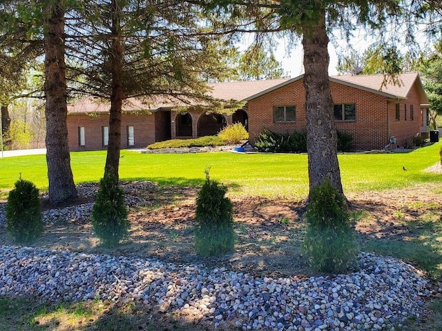 171 8th St, Clintonville, WI 54929 - view of front facade featuring brick siding and a front yard