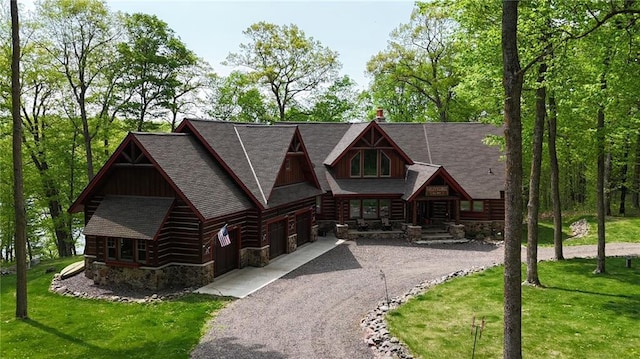 W735 County Road D, Birchwood, WI 54817 - cabin with stone siding, driveway, a front lawn, a garage, and a shingled roof
