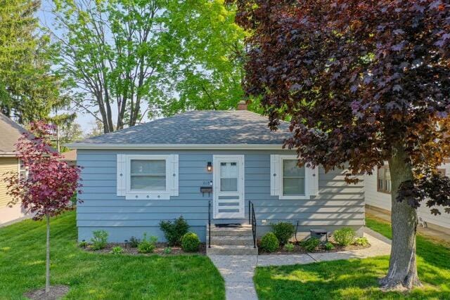 bungalow-style house with a front lawn
