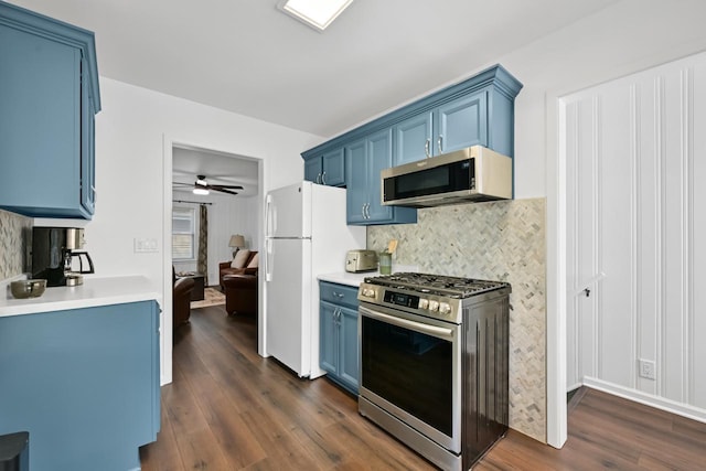 kitchen with stainless steel appliances, blue cabinetry, decorative backsplash, and dark wood-style flooring