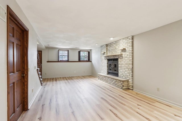 1714 Lewon Dr, Madison, WI 53711 - unfurnished living room featuring light wood finished floors, a fireplace, and baseboards