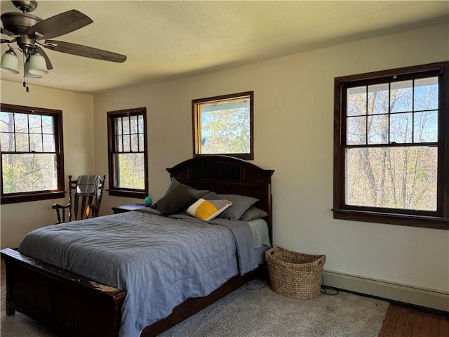 E6355 County Road D Dr, Colfax, WI 54730 - bedroom with a baseboard heating unit, baseboards, ceiling fan, and wood finished floors