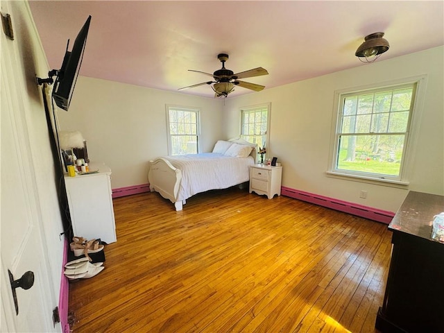 E6355 County Road D Dr, Colfax, WI 54730 - bedroom with a baseboard heating unit, light wood-style floors, ceiling fan, and baseboards